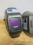 Jackson Auto Darkening Welding Helmet with (3) Older Fixed Shade Helmets and Bin of Tinted and Clear Glass Filler Plates- Auction Item